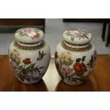 A pair of modern Chinese cloisonne enamel lidded jars, decorated with foliage and birds on a white