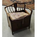 An Edwardian mahogany piano stool, with shaped and raised back and arms with central splat and