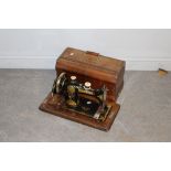 A vintage Jones hand crank sewing machine number 392898, with walnut veneered case, some marks, wear