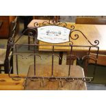 A wrought metal five bottle wine rack, 64cm wide x 12cm deep x 49cm high