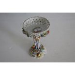 A 19th century Sitzendorf porcelain figural centre-piece, with pierced lattice bowl held by a