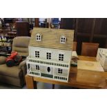 White painted three storey dolls house, with front veranda, 61cm x 49cm x 67cm high, containing some