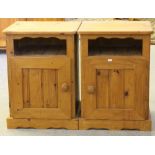 A pair of modern pine bedside cupboards, the square tops above open sections and panelled doors,