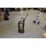 An oak two-division stick stand, with galvanised drip pan 69cm containing a bamboo shooting stick,