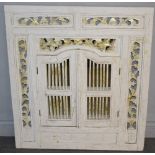 A decorative white-painted mirror with pierced foliate panels and arched spindled shutter doors 90cm