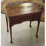 An 18th century oak lowboy, with moulded rectangular top above three short cockbeaded drawers each