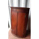 George III mahogany bowfront corner cupboard, the frieze with inlaid shell patera and stringing,