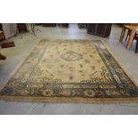 A large Chinese carpet, the cream field with central roundal and stylised motifs, enclosed by