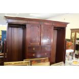 An Edwardian figured mahogany Gentleman's wardrobe, having a moulded cornice and sectioned frieze