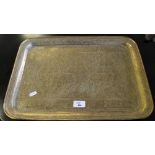 An eastern engraved brass tray, of rounded rectangular form with rolled rim, engraved with three
