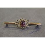 A 9ct gold and amethyst cabochon bar brooch, 5cm, 2.3grams in good condition.