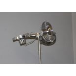 A pair of modern tall chromed coloured metal standard lamps, each head with three adjustable lights,