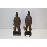 A pair of carved stained wood figures of German influence, marked to the base Kelly's Paraguay