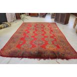 A Turkish carpet, the red field with stylized lozenge form motifs 415cm x 290cm stitched repair