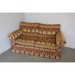 A Gainsborough two-seater settee, upholstered in Egyptian design material, originally purchased from