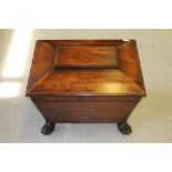 An early 19th century mahogany lead-lined sarcophagus-form cellarette wine-cooler, the hinged