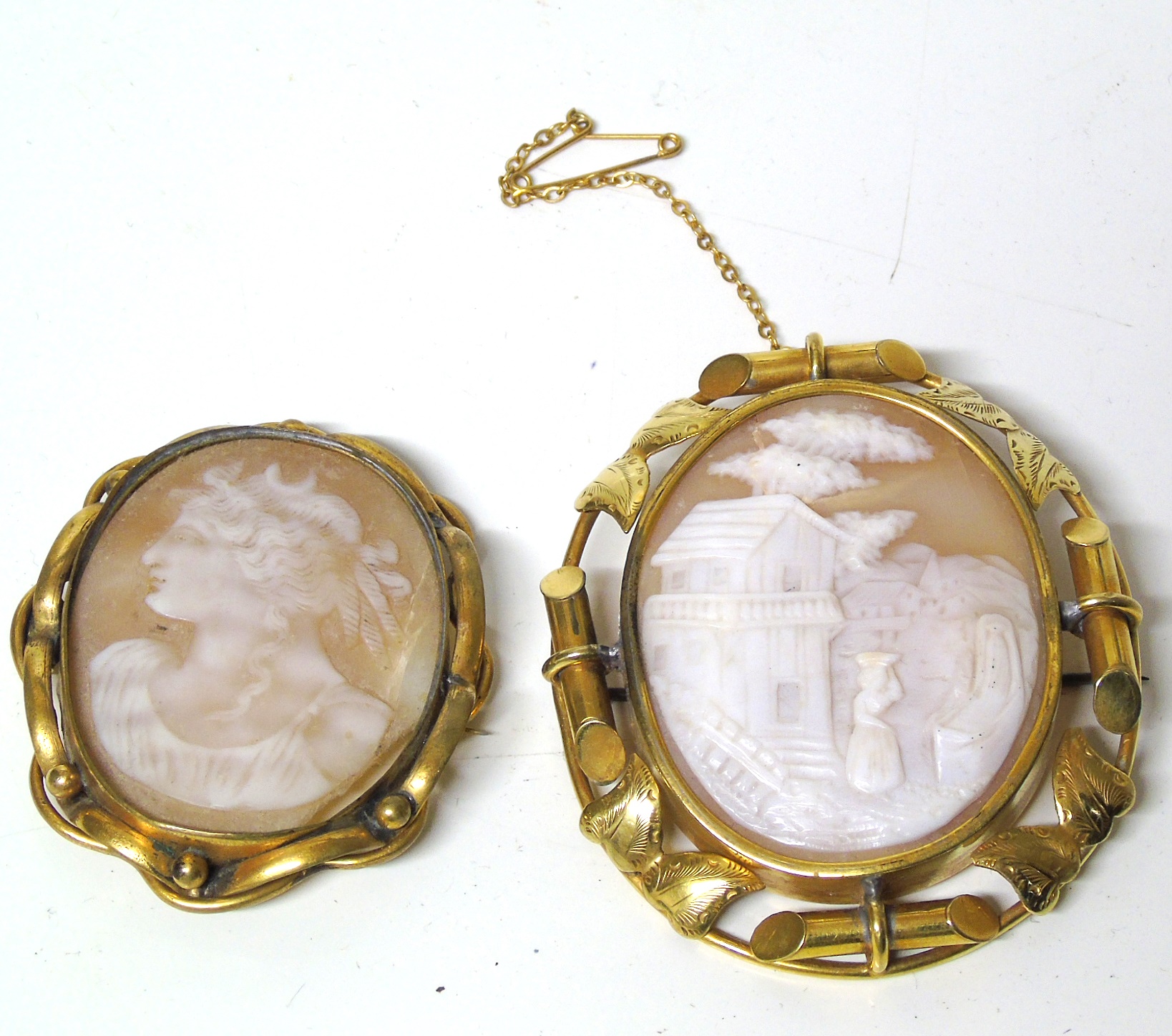 Two shell cameo brooches, one with a landscape scene the other depicting a classical figure,
