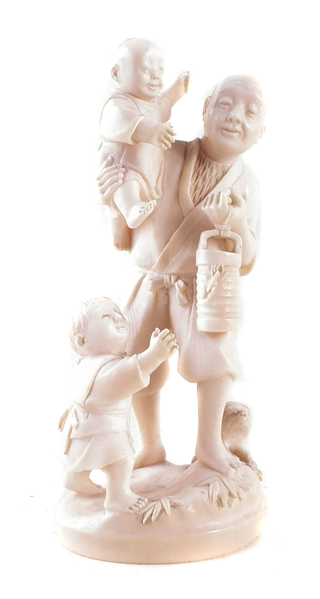 Japanese Ivory okimono, depicting a father and his two sons carrying a lantern with a dog at the