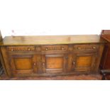 Reproduction oak dresser base enclosing three drawers and three cupboards, 198cm wide. We are unable