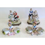 A pair of continental porcelain Vienna style figure groups and a pair of bisque bon bon dishes 20 cm