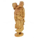 A Japanese Meji Period ivory okimono, depicting a sage with flowing beard, holding a series of