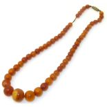 An amber style necklace, the graduated spherical beads with screw clasp, gross weight 17.2g. We