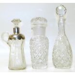 A silver topped clear glass jug and two cut glass decanters (3). We are unable to do condition