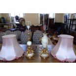 Two similar 20th century onyx and gilt table lamps, both bases modelled as three Cherubs with