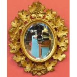 19th century oval gilt framed wall mirror, carved with leaves and berries, 43 x 34cm. Condition