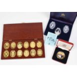 A cased set of twelve hallmarked silver gilt medallions and other cased gold-plated coin sets.