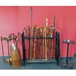 A hardwood walking cane stand containing 23 walking canes.