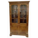 A late 20th-century honey-coloured oak display cabinet on cupboard,