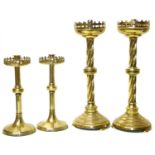 A pair of Victorian brass gothic design candlesticks