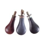 Three leather and brass powder flasks