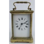 A carriage clock, with gilt metal and glass case, with white enamel dial and Roman numerals,