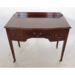 An early 20th century Heal's bow front mahogany knee-hole dressing table, with three drawers,