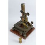 A Jas Parkes & Son Birmingham brass monocular metallurgical microscope, on a mahogany base, together