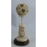 A 19th century carved ivory puzzle ball on stand, decorated with dragons and being pierced, height