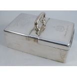 A silver cigarette box, of rectangular form, with central handle and two hinged flaps, with