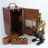 An E Leitz Wetzlar microscope, No 78698, in gilt and black lacquer finish, with various lenses, in a