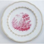An 18th century Doccia plate, the centre decorated with a puce landscape, with gilded border,