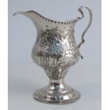 A Georgian silver cream jug, with embossed decoration of animals, birds, trees, cottage, etc,