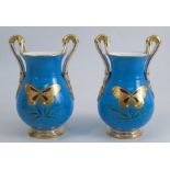 A pair of 19th century porcelain vases, decorated with a gilt and jewel butterfly to a rich blue