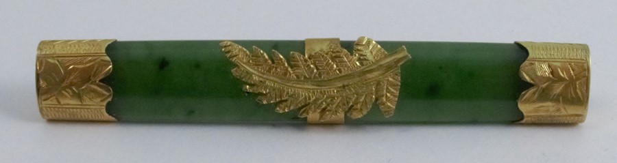 A nephrite bar brooch, the mounts stamped '9c', 6g gross