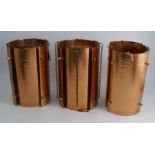 A set of three Arts and Crafts style cylindrical hanging lights, with beaten copper panels, height