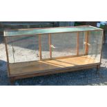 An oak and glass shop play counter, with sliding doors and shelves, 70ins x 23ins x 35.5ins