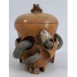 A 20th century carved wooden tobacco box and cover, formed as a skull with carved bone snake and