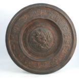 An Elkington & Co circular metal shield, decorated in relief with classical figures and motif,