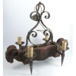 An unusual faux-wood rams mask four light chandelier, within a wrought iron frame with torch style
