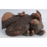 An Eastern carved wooden model, of a cockerel, hen and chicks, height 8ins, width 16ins